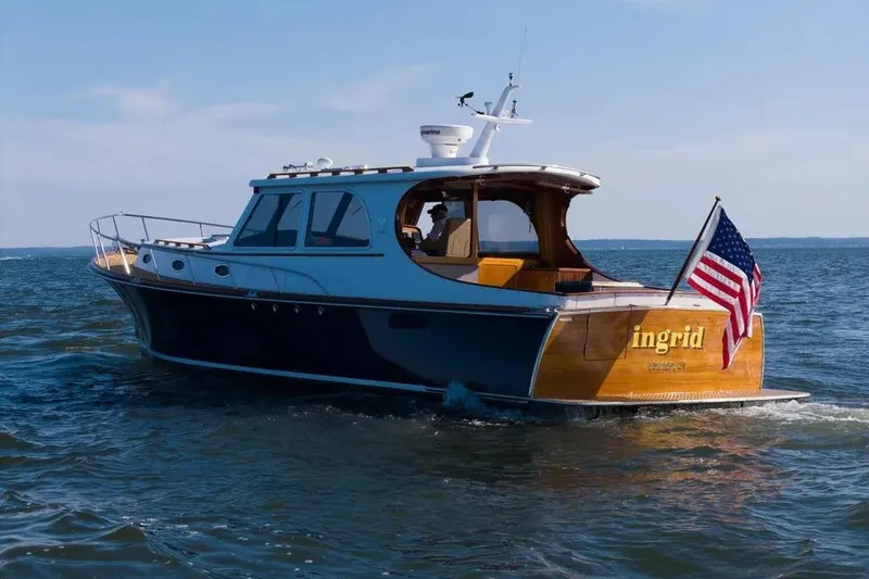 Slide: The Image of 2007 Gorbon Custom Downeast 40 yacht cruising with American flag on open water. - 3