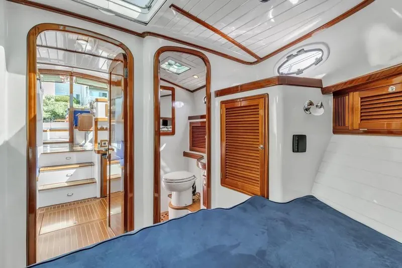 Slide: The Image of Luxurious interior of 2007 Gorbon Custom Downeast 40 yacht with wood accents and blue bedding. - 36