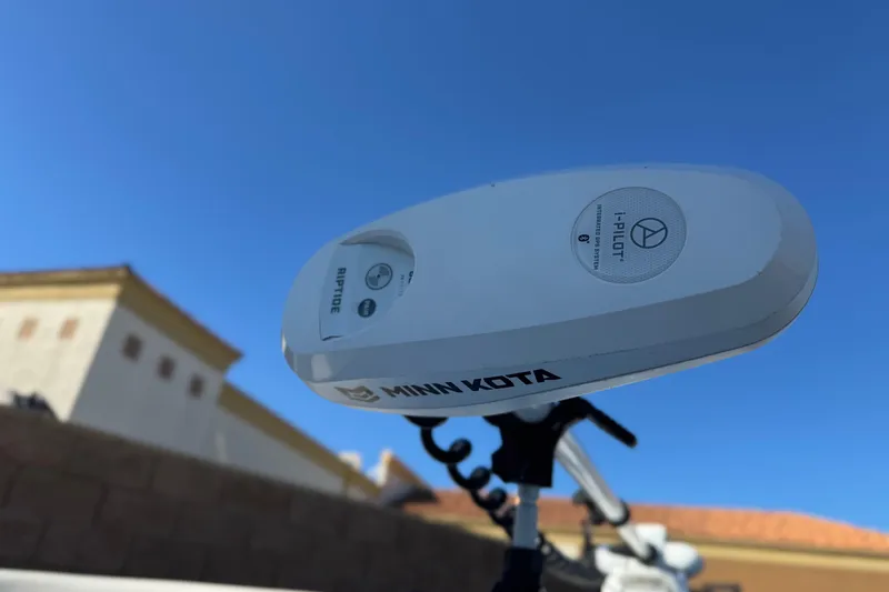 Slide: The Image of Minn Kota Riptide motor on 2023 Parker 21SE Center Console boat under clear blue sky. - 12