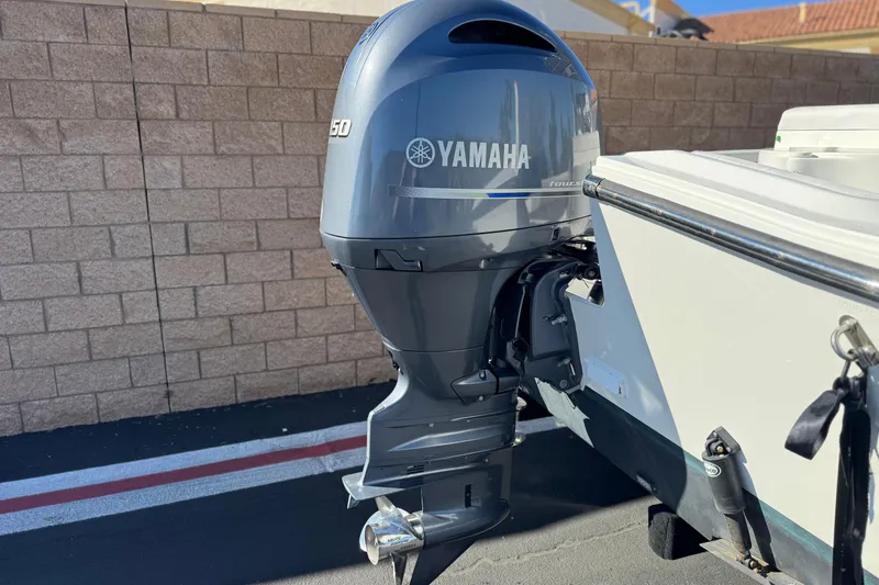 Slide: The Image of 2023 Parker 21SE Center Console with Yamaha outboard motor in a driveway. - 6