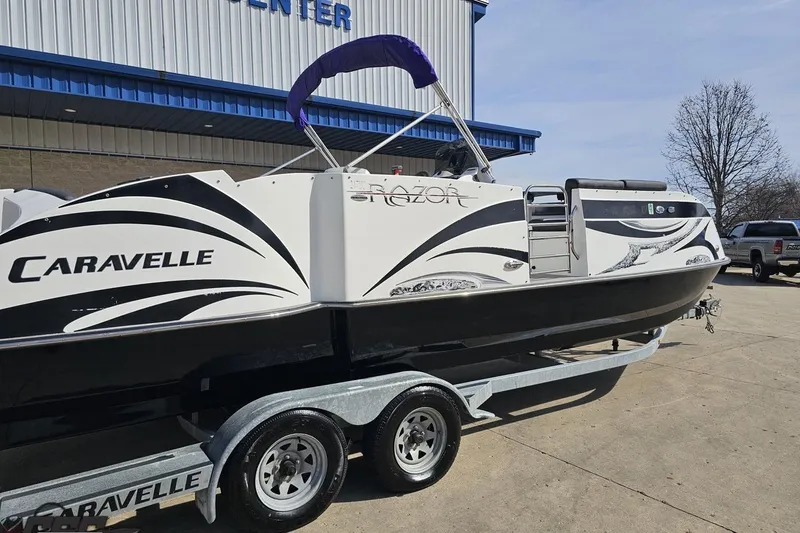 Slide: The Image of 2014 Caravelle 247 UU Razor E-Toon boat on trailer outside a building. - 11