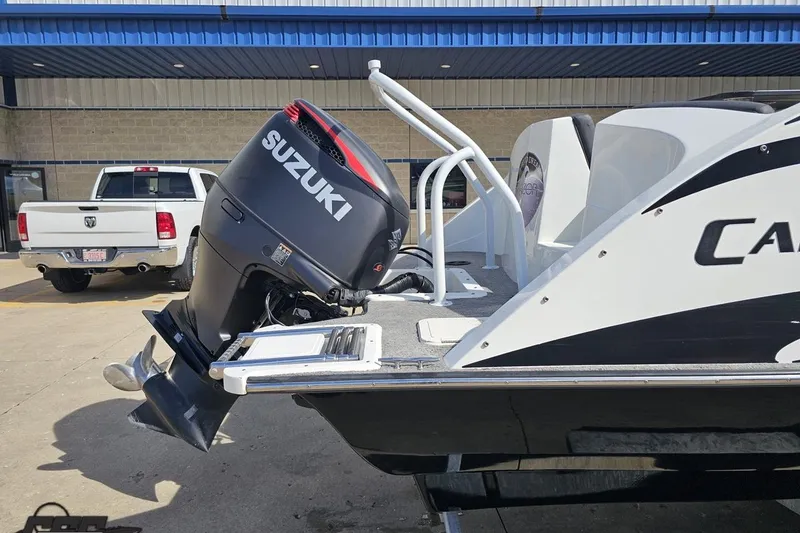 Slide: The Image of 2014 Caravelle 247 UU Razor E-Toon with Suzuki outboard motor at a dealership. - 13