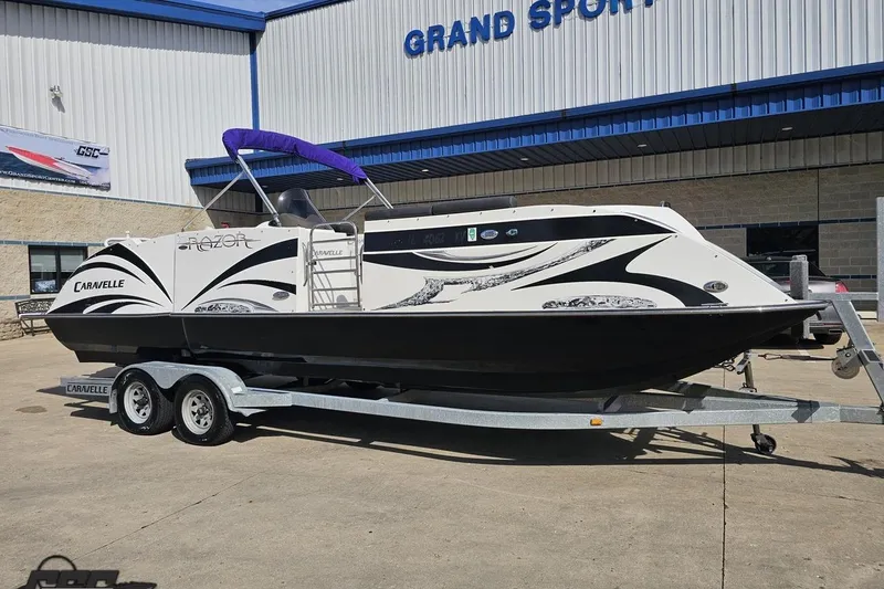 Slide: The Image of 2014 Caravelle 247 UU Razor E-Toon boat on trailer outside dealership. - 17