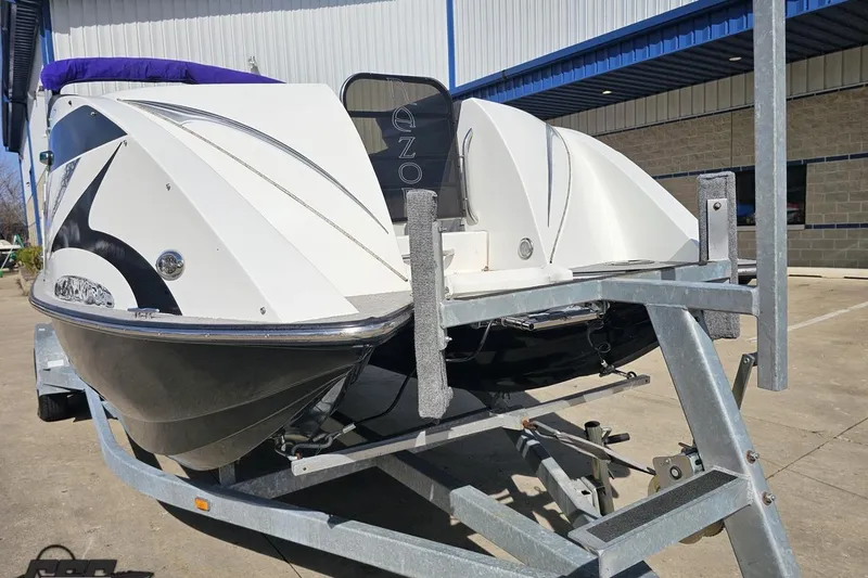 Slide: The Image of 2014 Caravelle 247 UU Razor E-Toon boat on trailer, parked outside a building. - 19