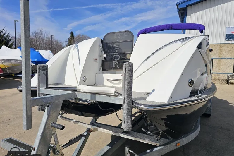 Slide: The Image of 2014 Caravelle 247 UU Razor E-Toon boat on trailer, outdoor setting. - 21