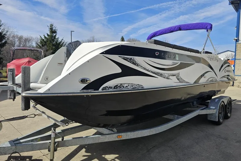 Slide: The Image of 2014 Caravelle 247 UU Razor E-Toon boat on trailer, featuring sleek black and white design. - 23