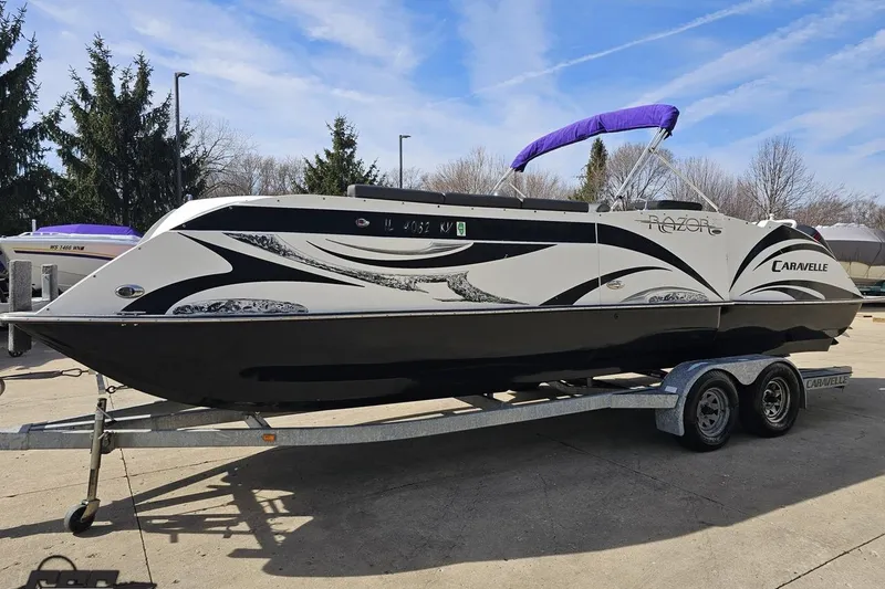 Slide: The Image of 2014 Caravelle 247 UU Razor E-Toon boat on trailer, parked outdoors. - 24