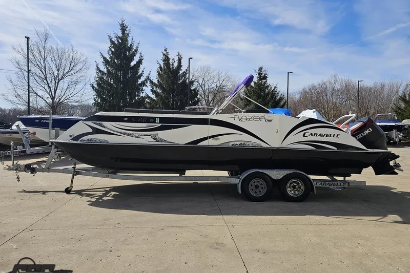 Slide: The Image of 2014 Caravelle 247 UU Razor E-Toon boat on trailer, parked outdoors. - 25