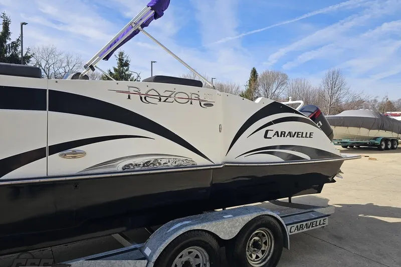 Slide: The Image of 2014 Caravelle 247 UU Razor E-Toon boat on trailer, parked outdoors. - 26