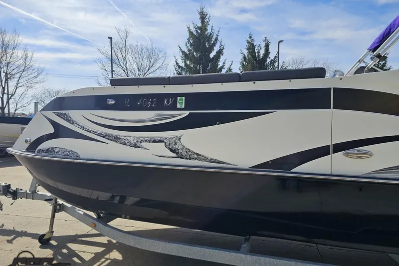 Slide: The Image of 2014 Caravelle 247 UU Razor E-Toon boat on trailer, sleek black and white design. - 27
