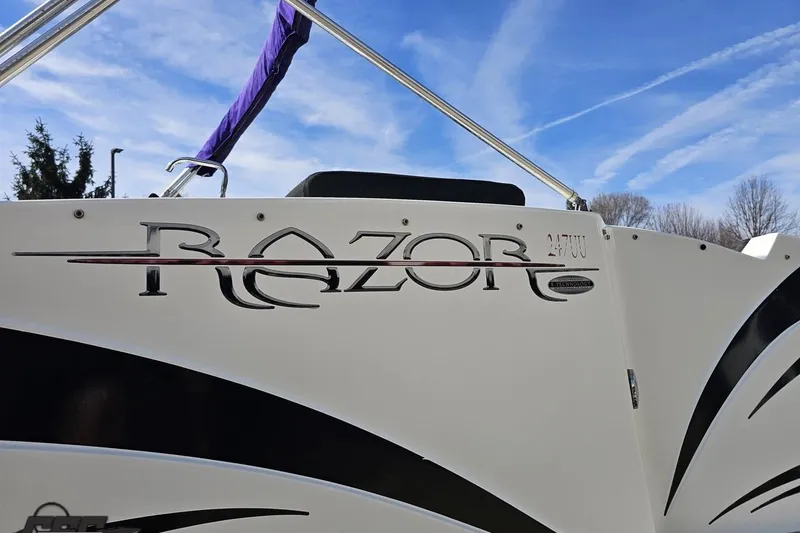 Slide: The Image of 2014 Caravelle 247 UU Razor E-Toon boat with sleek design and logo detail. - 28