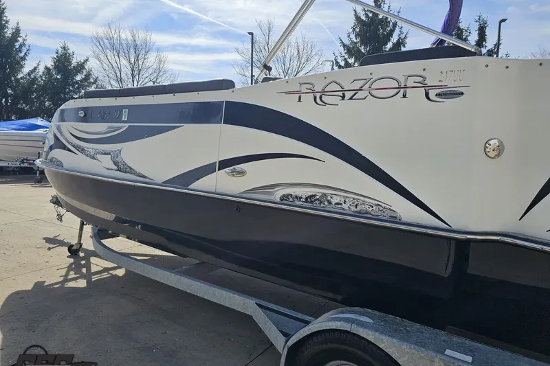 Slide: The Image of 2014 Caravelle 247 UU Razor E-Toon boat on trailer, showcasing sleek design and graphics. - 30
