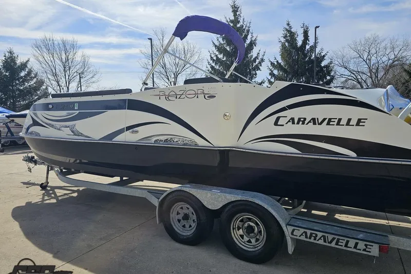 Slide: The Image of 2014 Caravelle 247 UU Razor E-Toon boat on trailer, outdoor setting. - 31