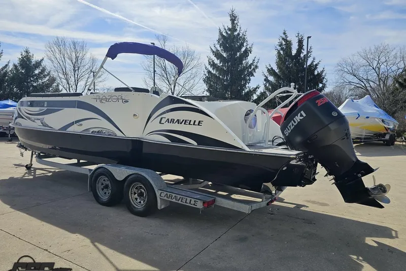 Slide: The Image of 2014 Caravelle 247 UU Razor E-Toon boat on trailer with Suzuki outboard motor. - 32