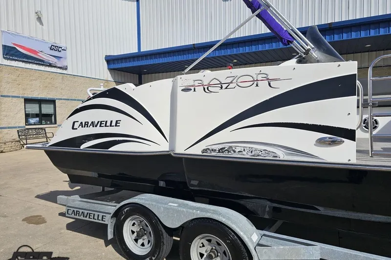 Slide: The Image of 2014 Caravelle 247 UU Razor E-Toon boat on trailer outside a building. - 6