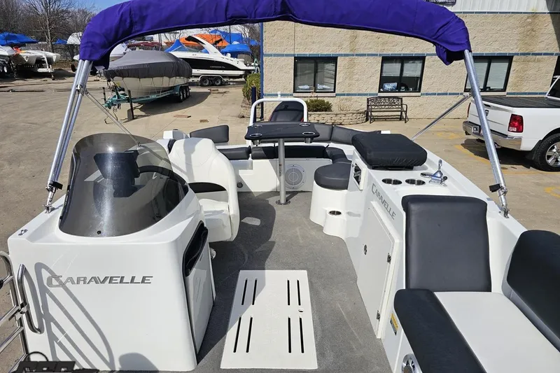 Slide: The Image of 2014 Caravelle 247 UU Razor E-Toon boat with seating and canopy in a marina setting. - 79