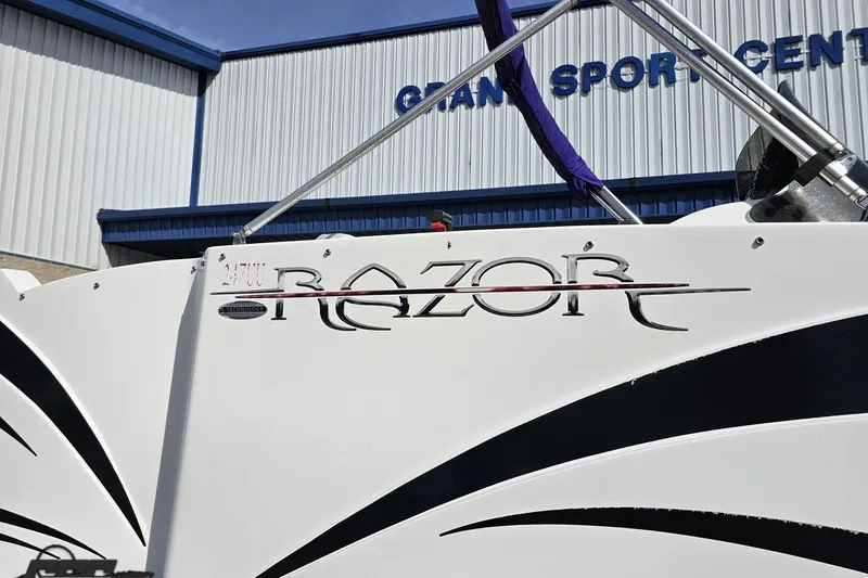 Slide: The Image of 2014 Caravelle 247 UU Razor E-Toon boat exterior with logo detail. - 8