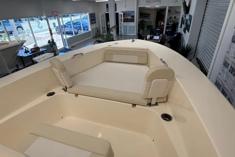 Slide: The Image of 2026 Scout 195 Sportfish boat interior with beige seating in showroom. - 10