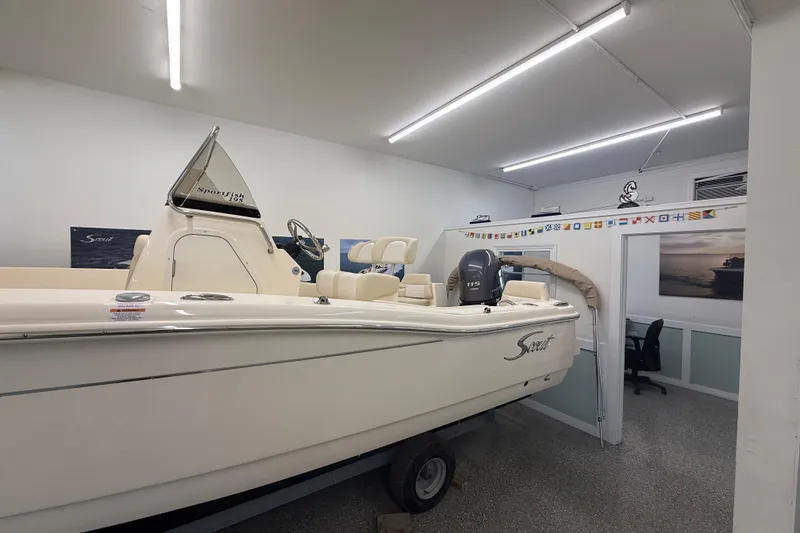 Slide: The Image of 2026 Scout 195 Sportfish boat displayed indoors with modern lighting. - 3