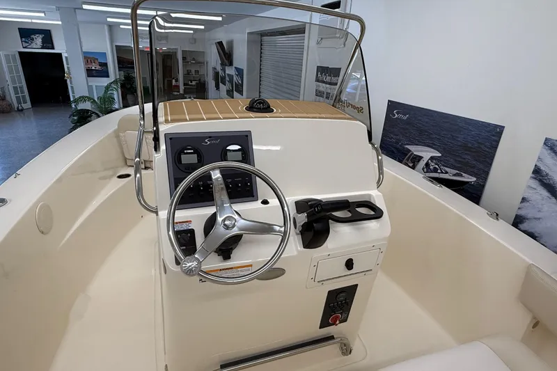 Slide: The Image of 2026 Scout 195 Sportfish boat interior with steering wheel and control panel. - 6