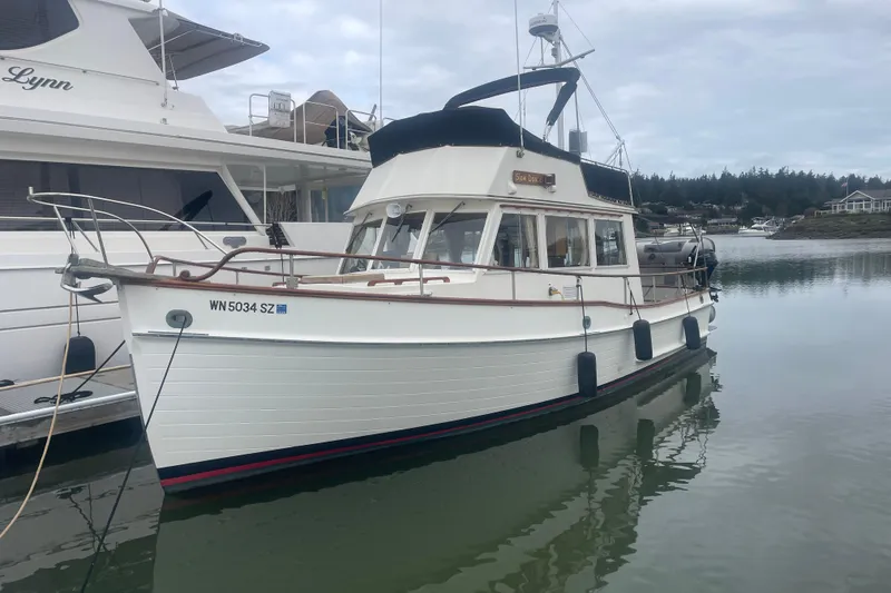 The Image of 1982 Grand Banks 32 Sedan boat docked in calm marina waters. - 0