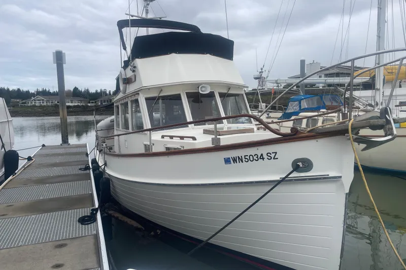 Slide: The Image of 1982 Grand Banks 32 Sedan docked at marina, overcast sky. - 1