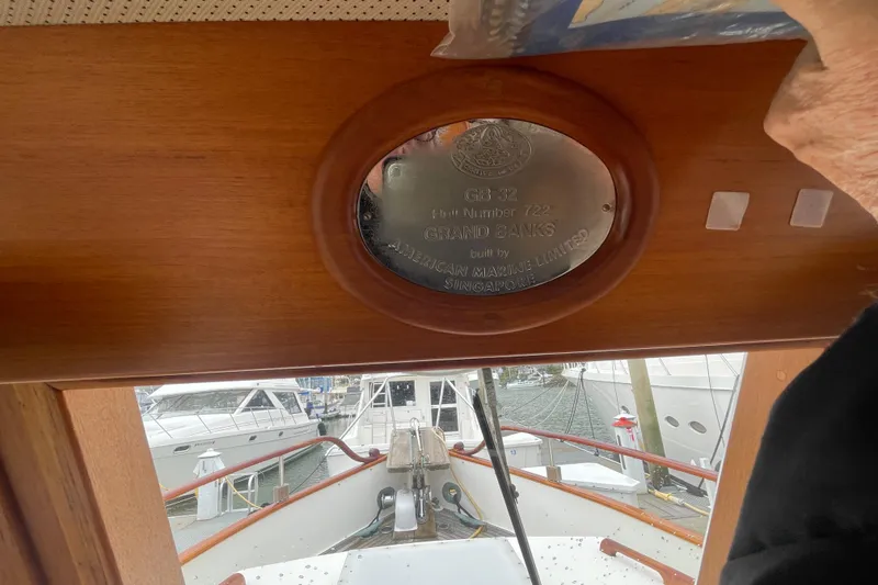 Slide: The Image of 1982 Grand Banks 32 Sedan interior with engraved plaque, docked at marina. - 11