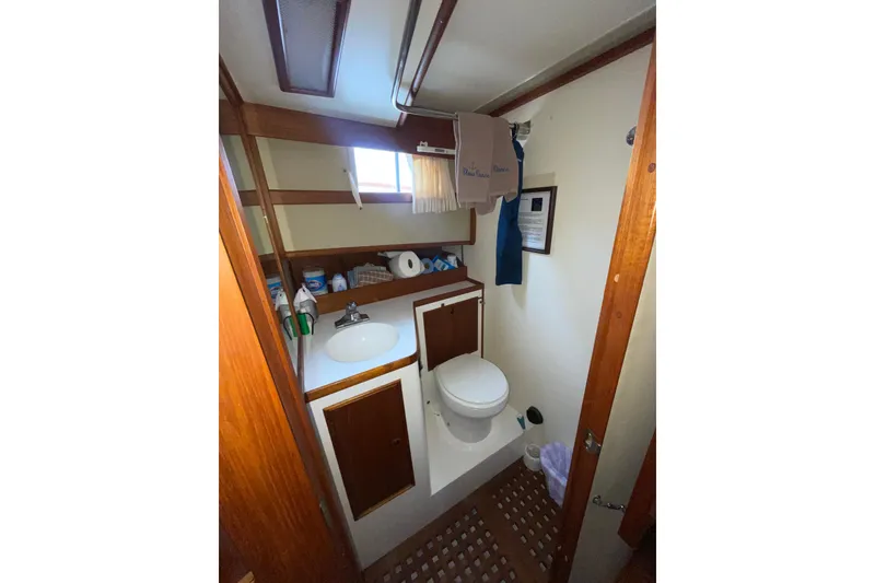 Slide: The Image of 1982 Grand Banks 32 Sedan bathroom with sink, toilet, and wooden cabinetry. - 24
