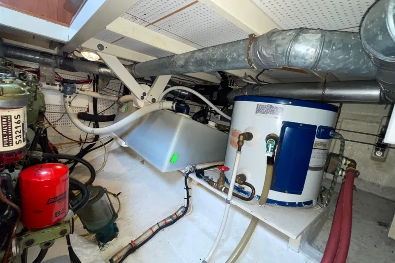 Slide: The Image of Engine room of a 1982 Grand Banks 32 Sedan, showcasing mechanical components and piping. - 30