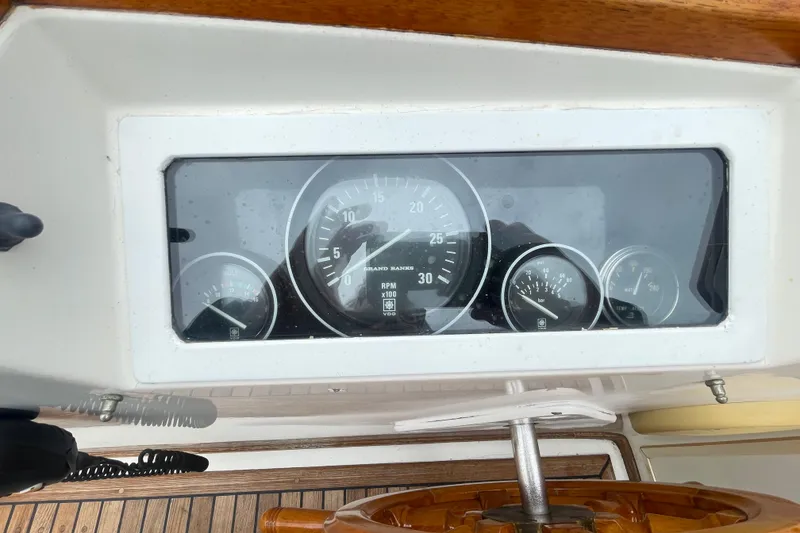 Slide: The Image of Dashboard of a 1982 Grand Banks 32 Sedan boat with gauges and steering wheel. - 50