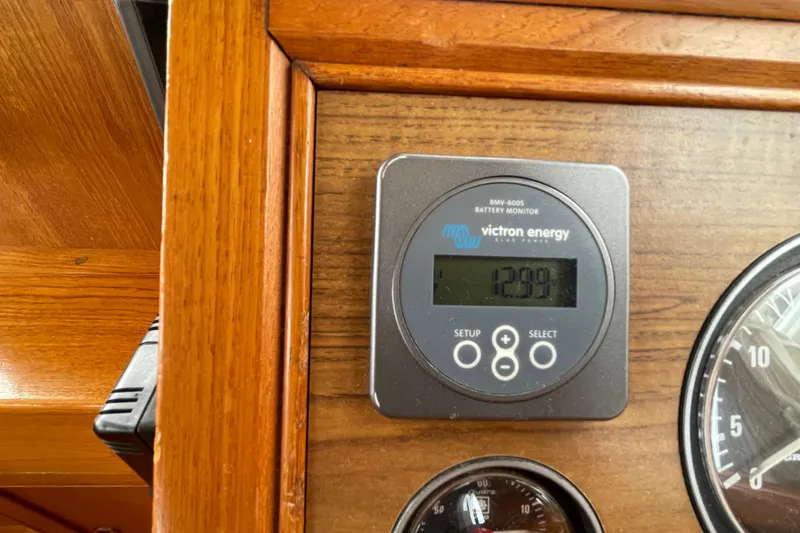 Slide: The Image of Victron Energy battery monitor on 1982 Grand Banks 32 Sedan dashboard, displaying voltage. - 8