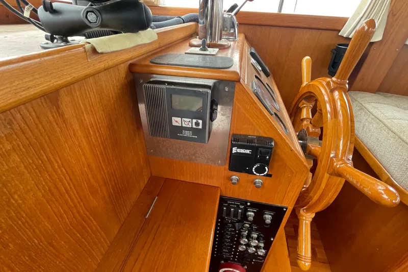 Slide: The Image of Interior helm of 1982 Grand Banks 32 Sedan with wooden steering wheel and control panel. - 9