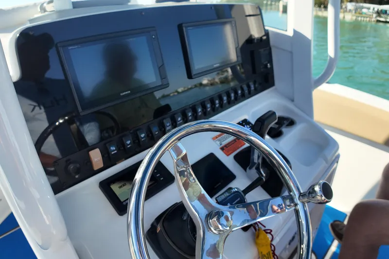 Slide: The Image of 2018 Sea Hunt Ultra 255 SE boat dashboard with steering wheel and navigation screens. - 10