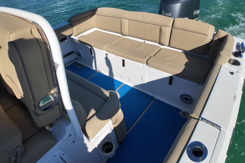 Slide: The Image of 2018 Sea Hunt Ultra 255 SE boat interior with tan seating and blue flooring. - 11