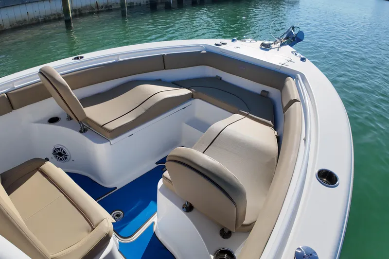 Slide: The Image of 2018 Sea Hunt Ultra 255 SE boat interior with beige seating and blue flooring. - 13