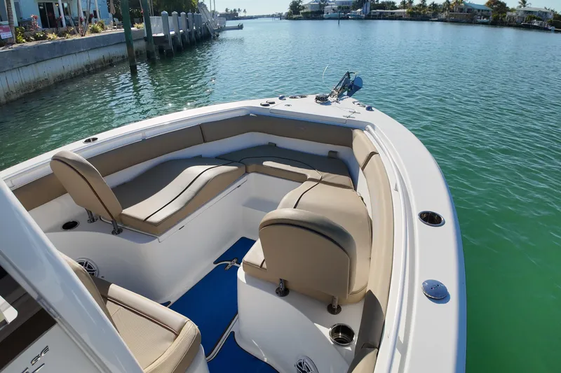 Slide: The Image of 2018 Sea Hunt Ultra 255 SE boat with spacious seating on calm water. - 17