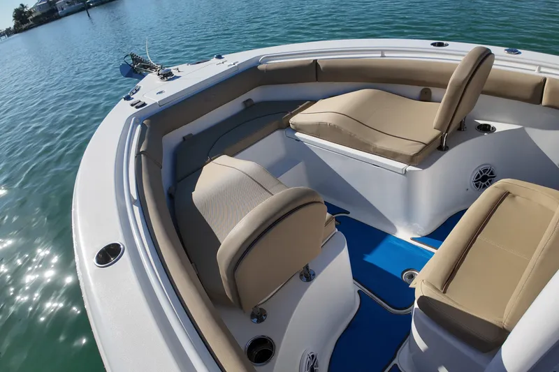 Slide: The Image of 2018 Sea Hunt Ultra 255 SE boat interior with beige seating on calm water. - 18