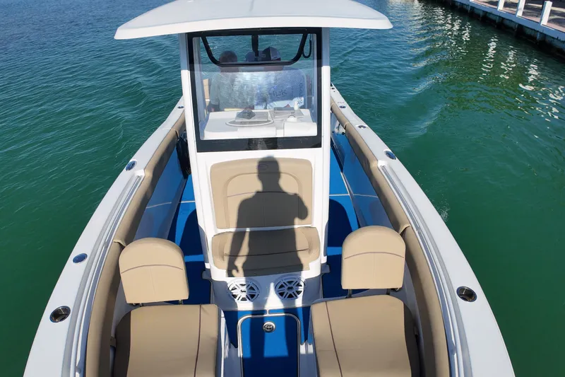 Slide: The Image of 2018 Sea Hunt Ultra 255 SE boat on calm water, featuring spacious seating and modern design. - 19