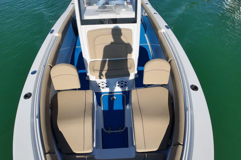 Slide: The Image of 2018 Sea Hunt Ultra 255 SE boat interior with beige seating and blue flooring. - 20