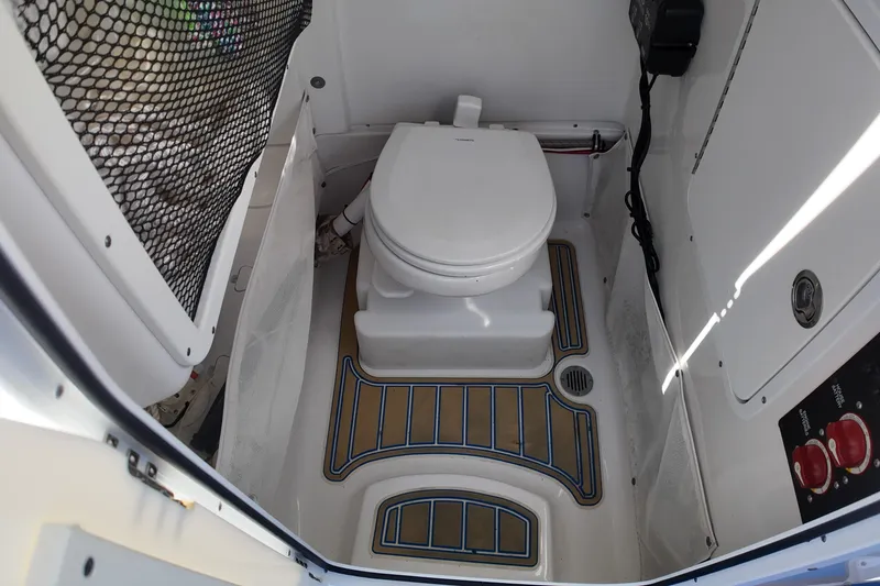Slide: The Image of 2018 Sea Hunt Ultra 255 SE boat interior with toilet and storage net. - 22