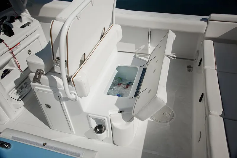 Slide: The Image of 2018 Sea Hunt Ultra 255 SE cruising on clear blue waters near a coastal town. - 5