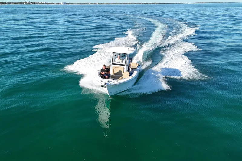 Slide: The Image of 2018 Sea Hunt Ultra 255 SE cruising on open water, creating a wake. - 8