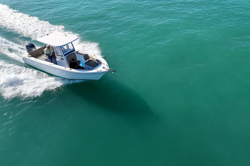 Slide: The Image of 2018 Sea Hunt Ultra 255 SE cruising on clear turquoise water. - 9