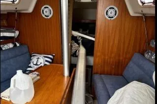 Slide: The Image of Interior of a 1997 Catalina 28 MkII sailboat with wooden paneling and blue seating. - 5