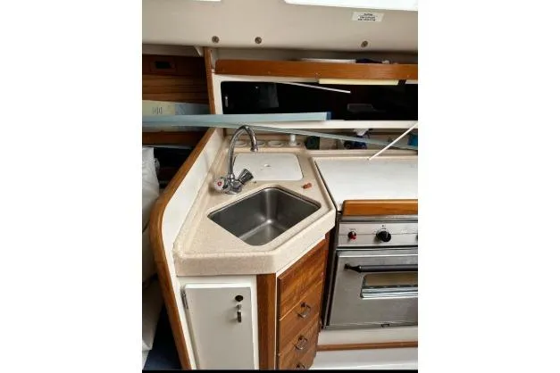 Slide: The Image of 1997 Catalina 28 MkII yacht kitchen with sink, stove, and wooden cabinetry. - 6