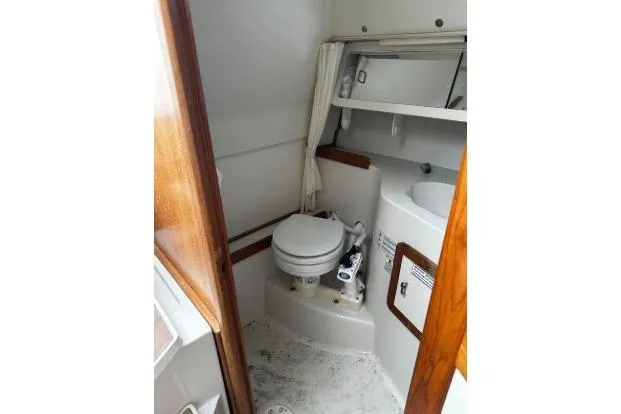 Slide: The Image of 1997 Catalina 28 MkII boat bathroom with toilet, sink, and wooden accents. - 7
