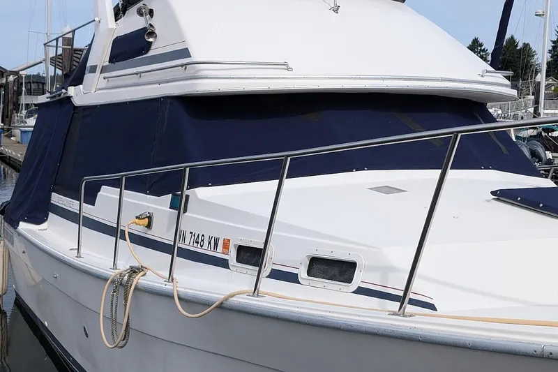 Slide: The Image of 1986 Bayliner 3270 Motoryacht docked, featuring sleek design and blue canvas covers. - 1