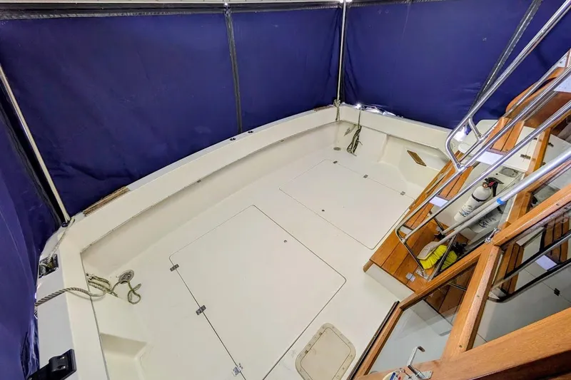 Slide: The Image of 1986 Bayliner 3270 Motoryacht cockpit with blue canopy and wooden stairs. - 11