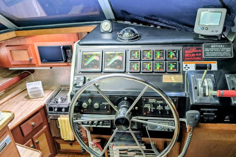 Slide: The Image of 1986 Bayliner 3270 Motoryacht helm with steering wheel, gauges, and control panel. - 14