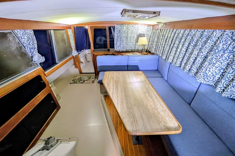 Slide: The Image of Interior of 1986 Bayliner 3270 Motoryacht with blue seating and patterned curtains. - 16